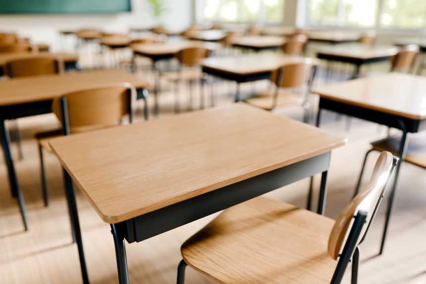 Desks and chairs arranged in classroom setting, perfect for students to engage in their studies. 3d render.