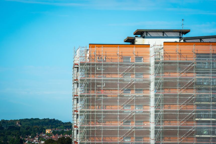 Scaffold sheeting net wrapped apartments building during insulation in england uk.