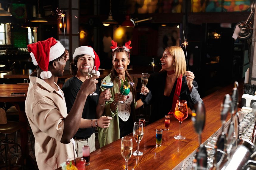 Colleagues enjoy a lively evening at a vibrant venue, raising glasses and sharing laughs.