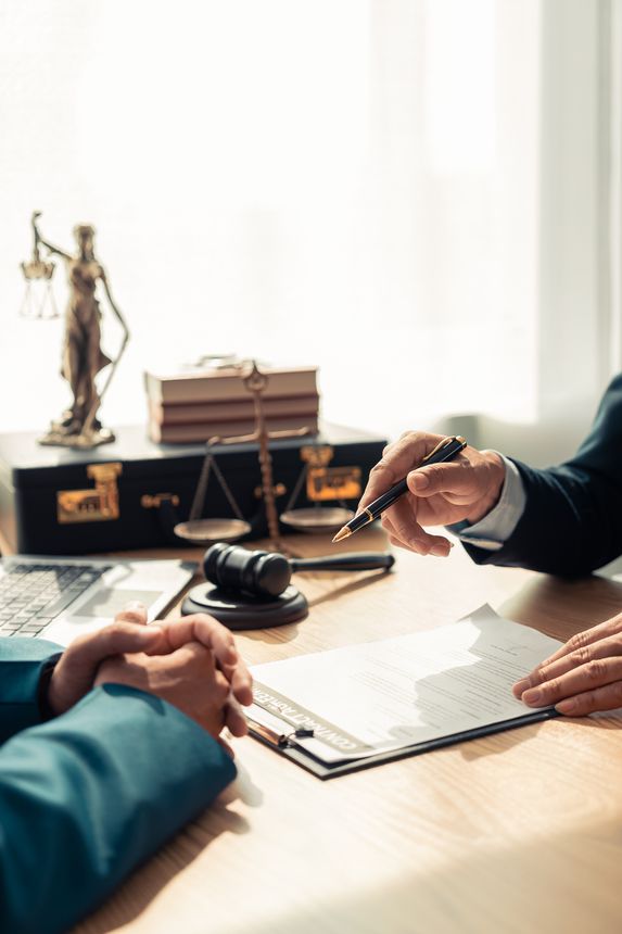 Meeting of business lawyers working on legal issues in the courtroom to help clients, lawyers working with notebooks, working with documents to prepare for litigation. Close-up vertical image