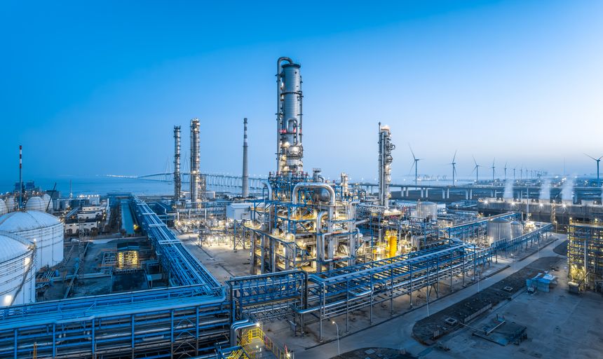 Detailed view of complex industrial equipment, pipes, and structures within a petrochemical plant landscape, representing business and technology.