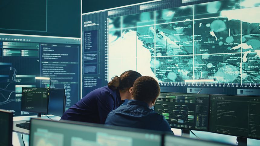 Governmental hackers using advanced software to protect against cyber threats, working in team. Specialists on cyber security, data and network protection unite forces in high tech office. Camera B.