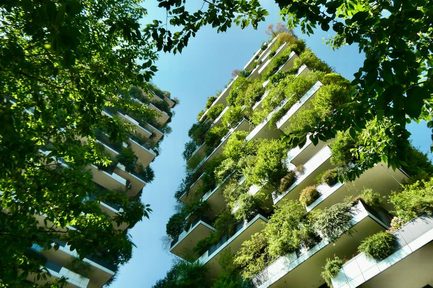 Skyscraper with trees on balconies with leaves in foreground