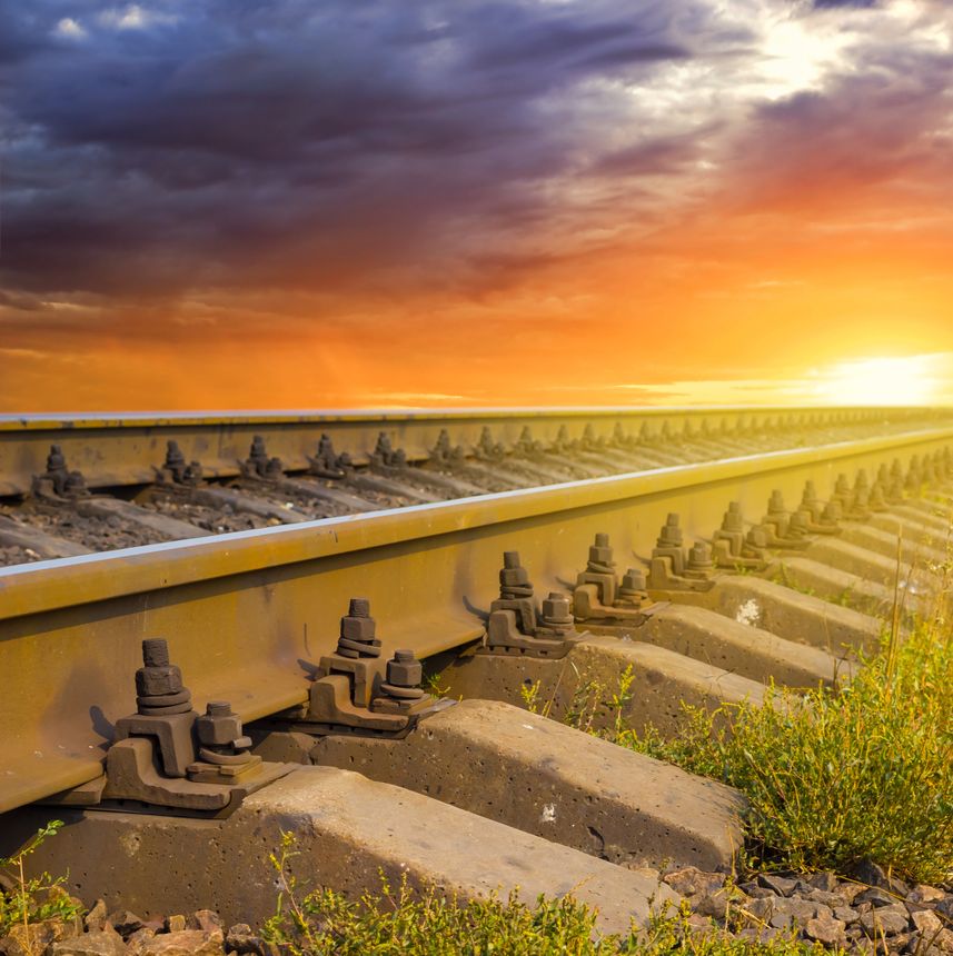 closeup railway among fields at the dramatic sunset