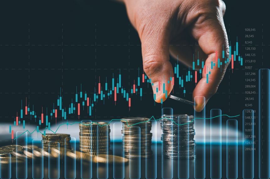 Professional hand stacking coins with an overlay of digital stock market candlestick charts. Concept of financial growth, investment strategy, capital accumulation and wealth management analysis.