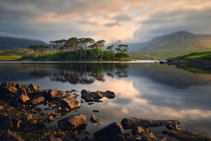 Beautiful sunrise lakeside landscape scenery of twelve pines island surrounded by mountains at Derryclare, connemara national Park in County Galway, Ireland