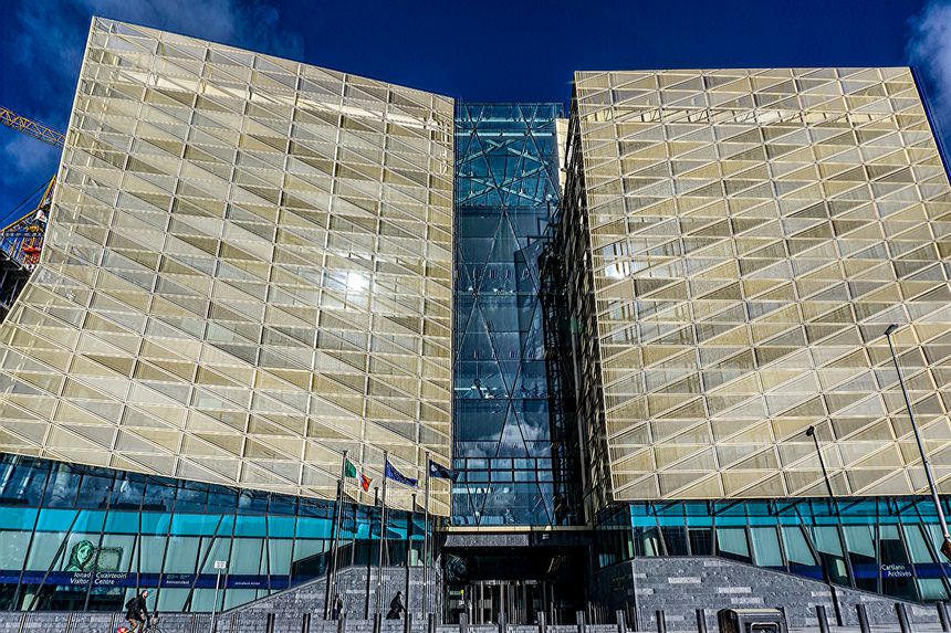 A cyclist passes the imposing facade of the Irish  Central Bank Building at North Wall Quay, Dublin, Ireland.
