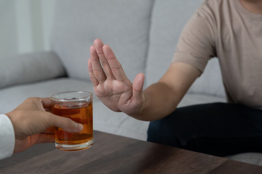 man refuses say no and avoid to drink an alcohol whiskey , stopping hand sign male, alcoholism treatment, alcohol addiction, quit booze, Stop Drinking Alcohol. Refuse Glass liquor, unhealthy, reject