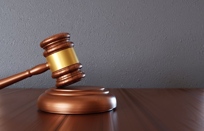 Wooden judge gavel on the desk near gray wall. Law and justice concept. 3d-rendering