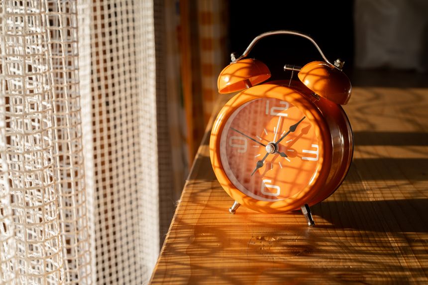 Alarm clock close-up in the rays of sunlight in the morning. Early rise