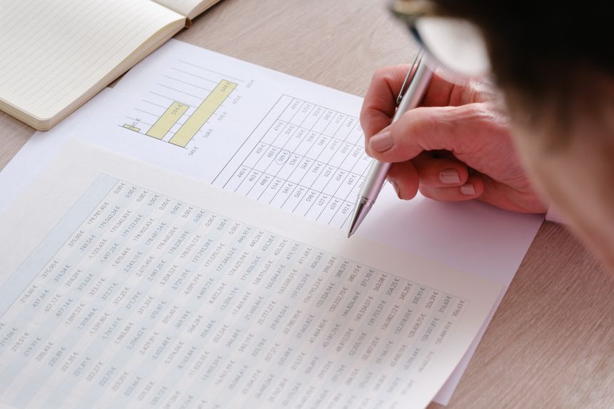 Businessperson analyzing financial data and charts with a pen