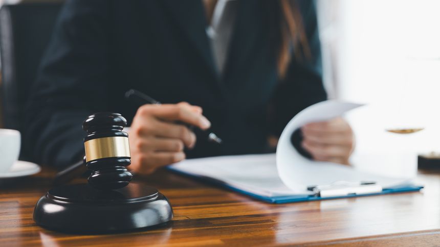 Justice and lawfirm concept. Female lawyer in office with brass scale. Woman hand gavel to bang. Law and justice trial session. Business lawyer notary stamping agreement, company secretary, validity.