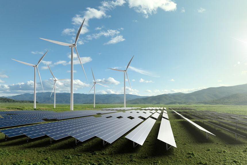 Solar farm and wind turbines in mountain valley with lake view