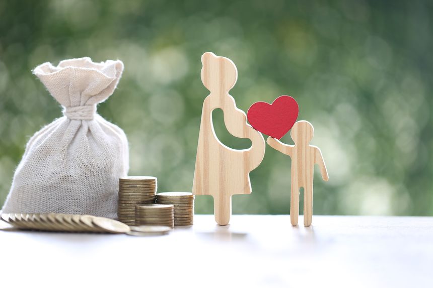 Pregnant woman and coin money on natural green background,Save money for prepare in future and newborn baby concept