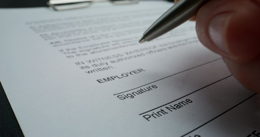 A man puts his signature on an employment contract, close-up of his signature, an unrecognizable person