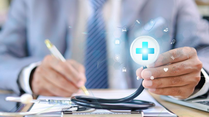 Doctor holding stethoscope with digital medical cross interface while signing document. Concept of healthcare service, health insurance, and medical protection.