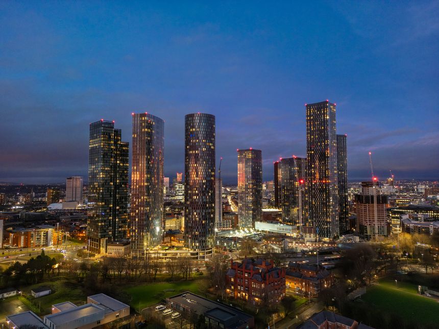 A vibrant cityscape showcasing the illuminated skyscrapers of Manchester at night, emphasizing the urban development and modernity of this iconic UK city.