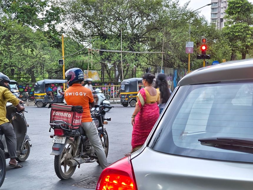 Mumbai, India - 23 June 2025, Picture of a Swiggy's delivery agent with a bag of Zomato. Food delivery, listed, stock market, loss, profit, blinkit, zepto, traffic, quick delivery, grocery, demand.