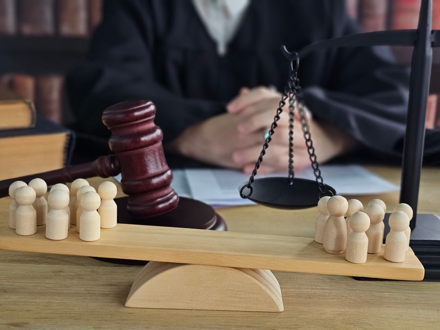 Courtroom scene with wooden figures representing a jury and a judge presiding over a trial during a legal proceeding