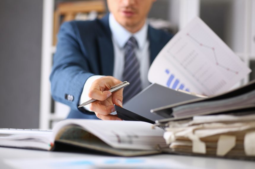 Male hands hold documents with financial statistics at office workspace closeup. White collar check money papers, stock exchange market, internal Revenue Service inspector, earning list concept