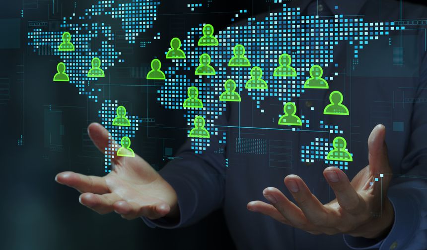 Businessperson holding world map and people icons.