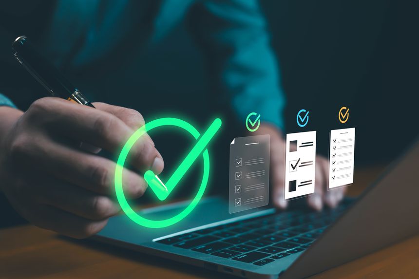 Businessman using digital checklist on laptop, symbolizing task management, productivity, workflow efficiency. Concept of online approval, data verification, and digital project completion in modern