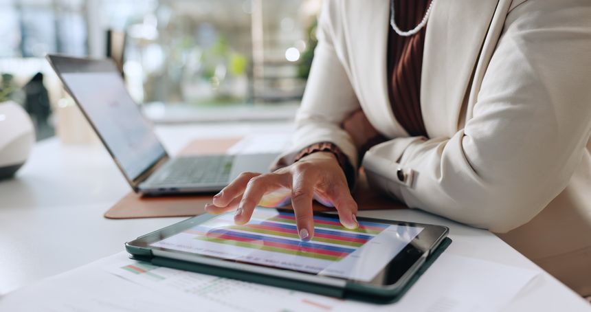 Hands, business person and graph on tablet for accounting, financial planning and budget review. Woman, laptop and report with finance results, statistics document and online expenses in office