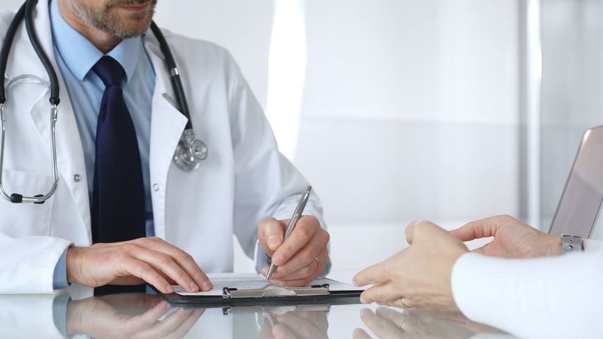 Doctor talking to patient, explaining medical information and healthcare options during a consultation at a modern clinic. Medicine, healthcare and science concept