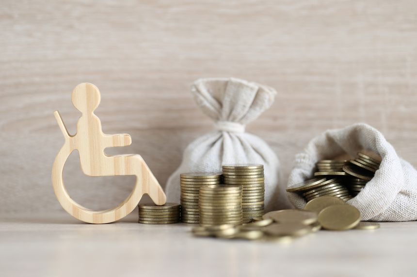 Man on wheelchair and coin money on wooden background,Save money for prepare in future and handicapped person concept