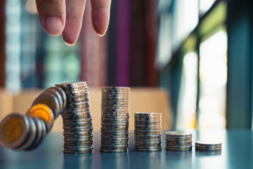 Financial investment risk and failure concept with falling coins stack and businessman hand. Economic crisis, business loss, bankruptcy, inflation and market crash background.