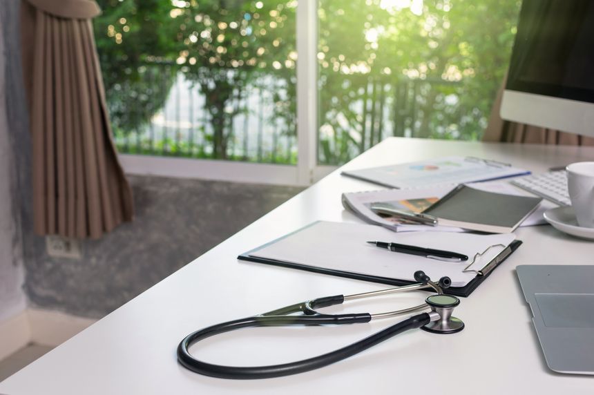 Stethoscope on the workplace table with some part of computer set and keyword with paper document office in the modern hospital or clinic, healthcare and physician concept