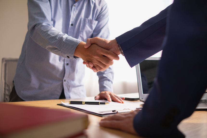 Businessmen and investors discussed joint venture within the legal counsel office and agreed to sign a contract in front of the lawyers within the legal counsel office to witness the joint investment.