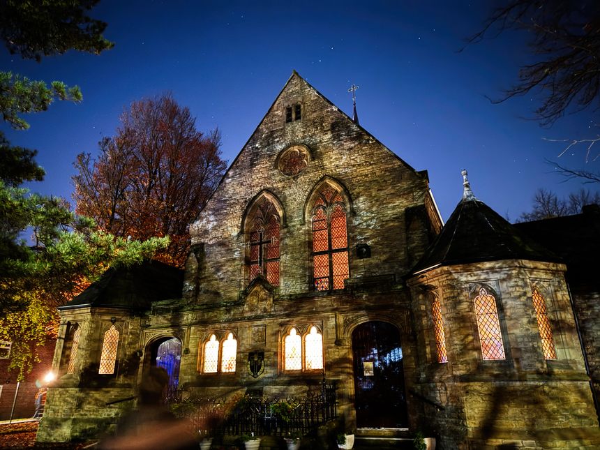 Salford, UK - November 08, 2025: stone church in Salford at night, warm light from stained glass windows creates atmosphere. The Dormition of the Holy Mary Mother Of God Ukrainian Catholic Church