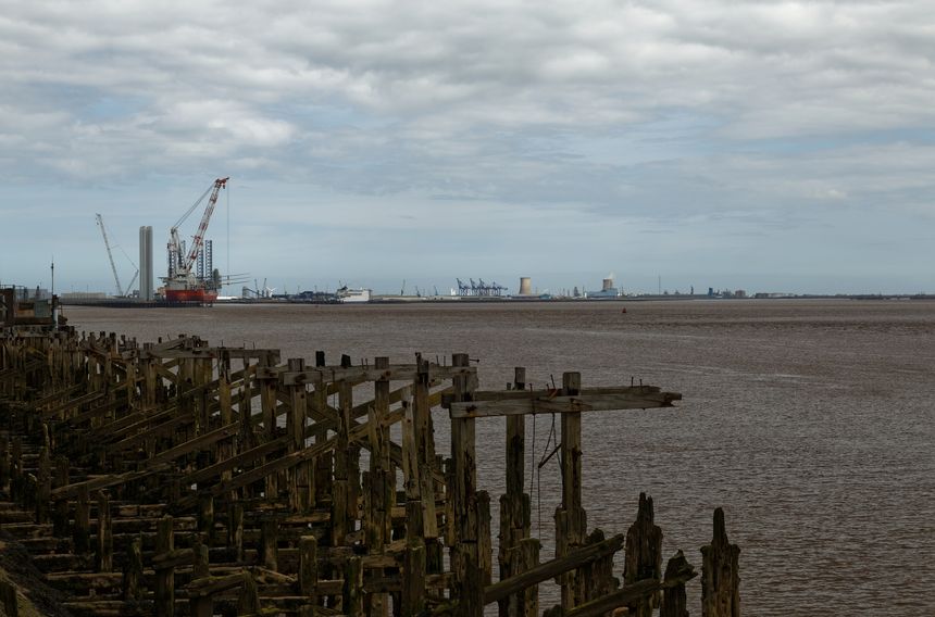 An old,dilapidated pier,and in the background the port infrastructure.England