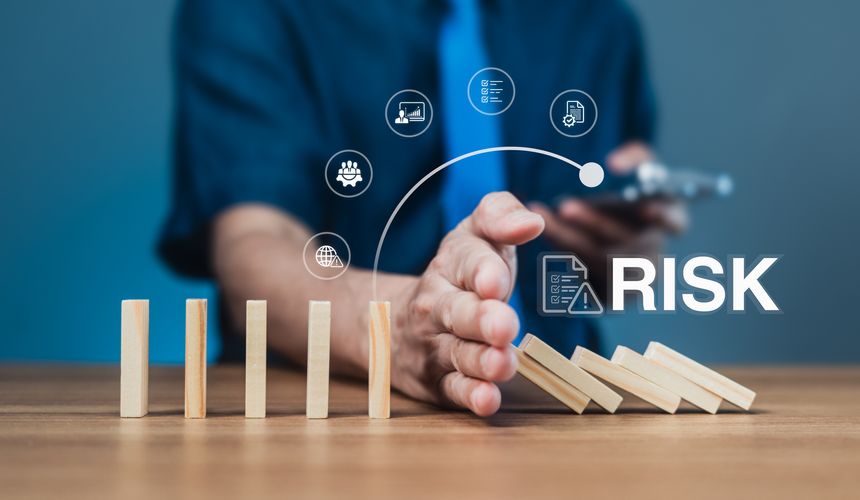 Businessman stops falling dominoes with hand, showing risk prevention, proactive strategy, and business control. Abstract icons represent global issues, teamwork, and documentation