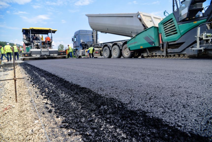Heavy duty road building. Hot Asphalt being laid and measured for a quality check as a part of a on site control test.