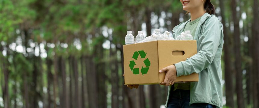 Recycling concept. Women holding a cardboard box with a water bottle with a recycling symbol. Management for a sustainable environment. Save the Earth Environment World. Net Zero. Reuse reduce recycle