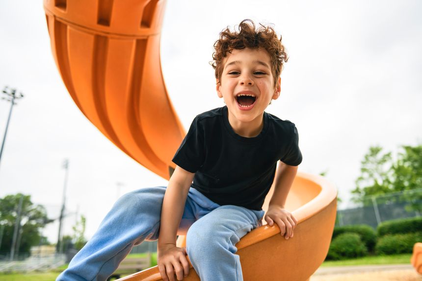 A Happy kid slide on playground on summer season