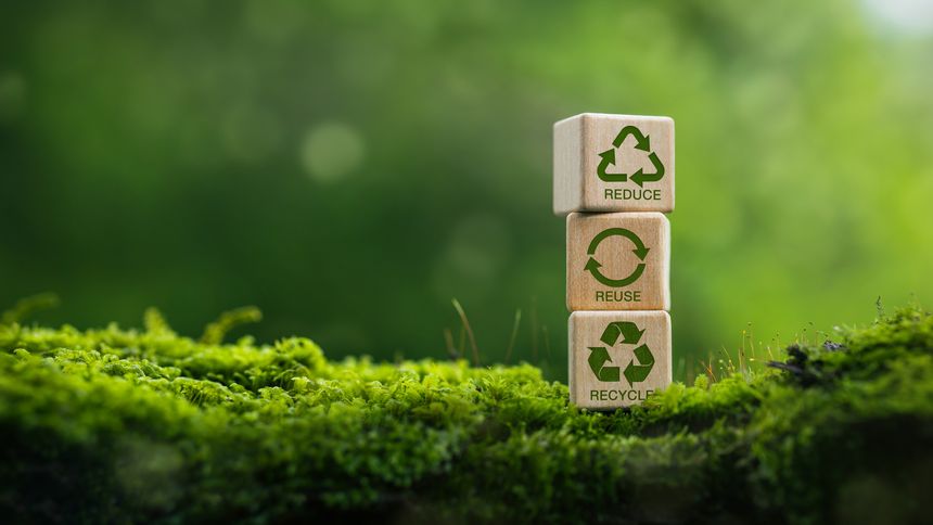 Recycle symbol on wooden blocks in green nature background. Eco concept for recycling, sustainable living, and environmental conservation.