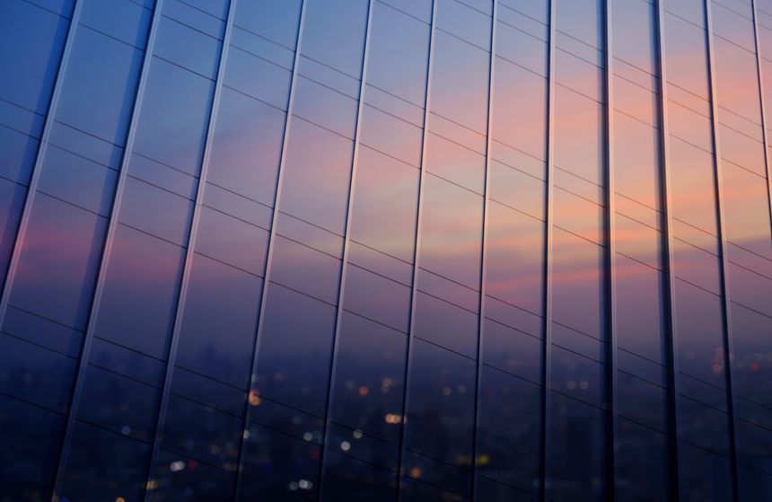 Reflection of blurred cityscape in metal wall of office building