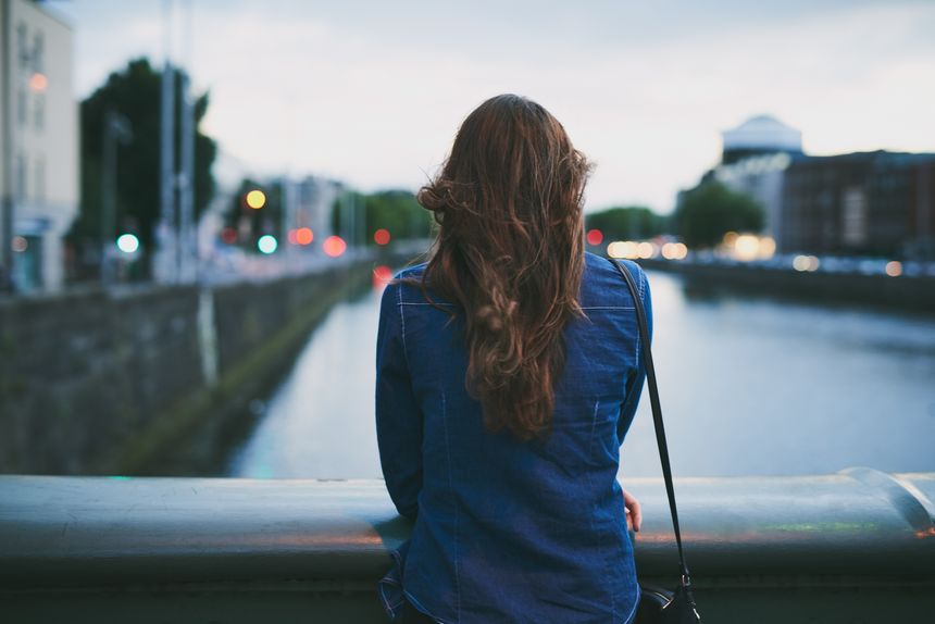 Rearview shot of an unrecognizable young woman taking in the city views while standing on a bridge