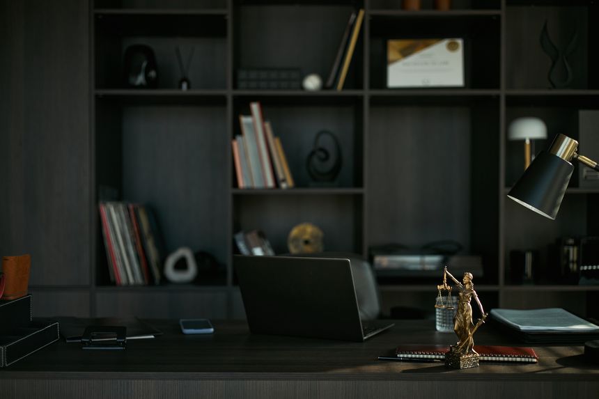 Wide shot of lawyer office desk displaying laptop, smartphone, legal files, Lady Justice statue, suggesting divorce consultation and family law services. Ideal for legal marketing