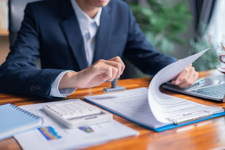 Man carefully reviewed finance agreements and contract documents with his client, discussing loan, mortgage, investment opportunities, credit terms, and tax implications for their business.