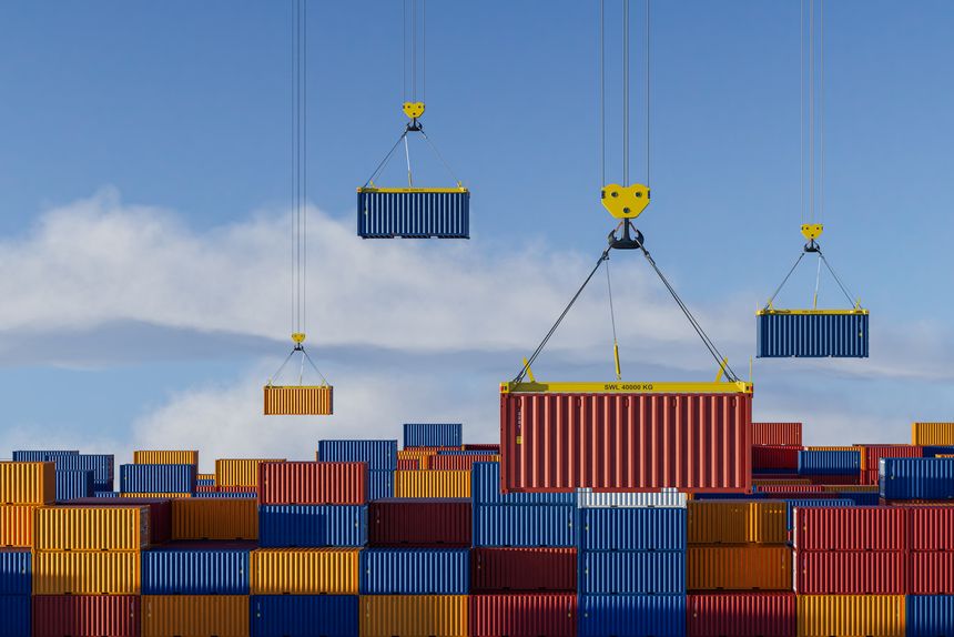 Multiple cranes operating in busy container port and freight yard