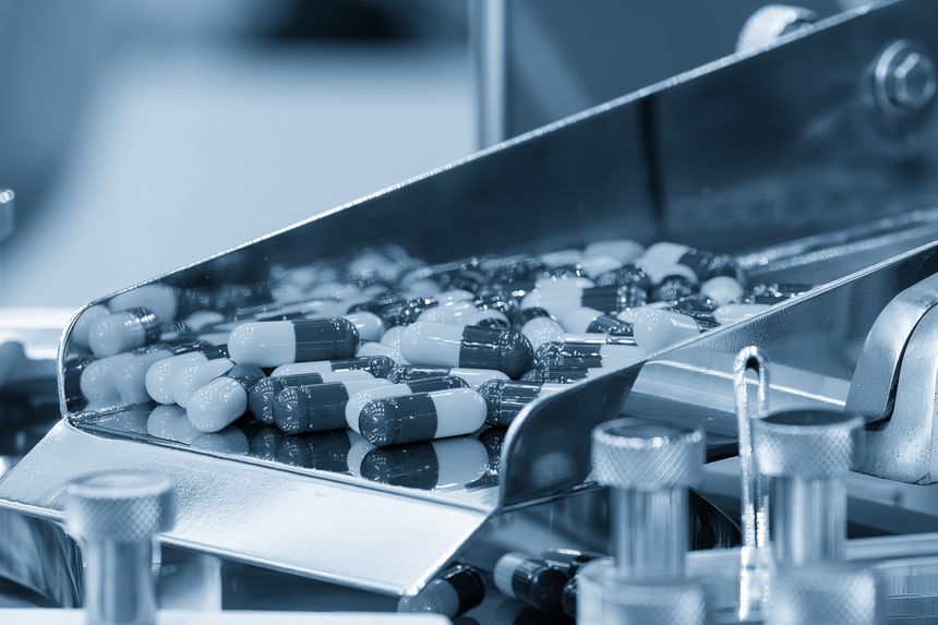 Close up scene the capsules drug mass production process in the light blue scene. Pharmaceutical Manufacturing Tablet.