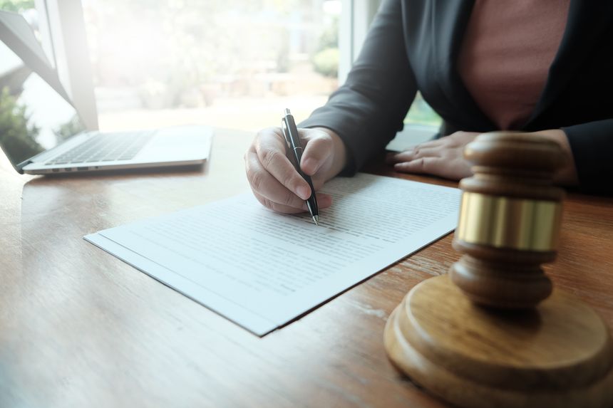 Legal counsel presents to the client a signed contract with gavel and legal law. justice and lawyer law of advisor Concepts