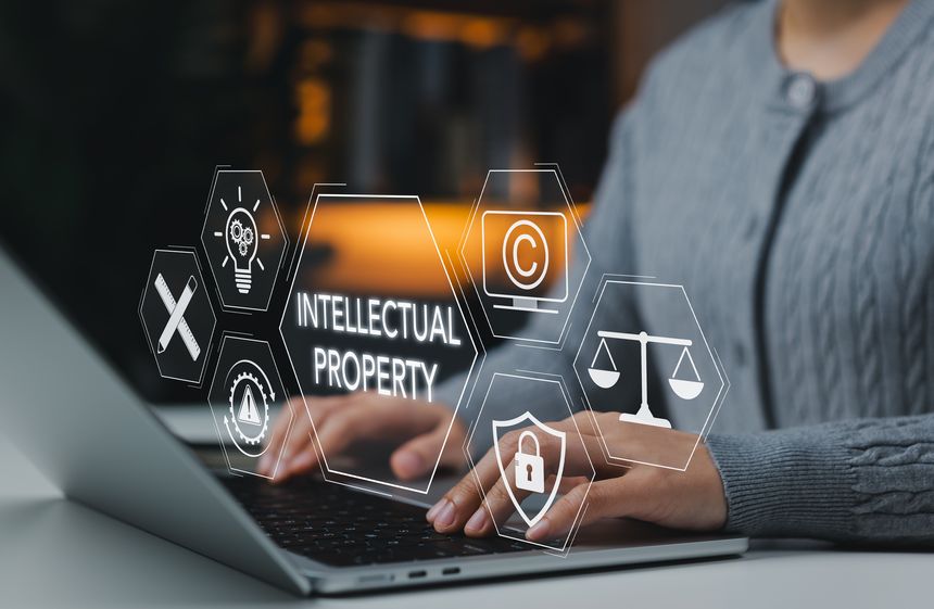 Intellectual property protection concept. Woman working on laptop with copyright, patent, security, and legal icons representing digital rights, trademark law, and creative ownership protection.