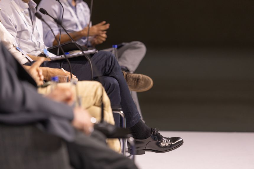 Business panelists speaking during a corporate conference, featuring microphones, executive discussion, leadership debate and professional networking event