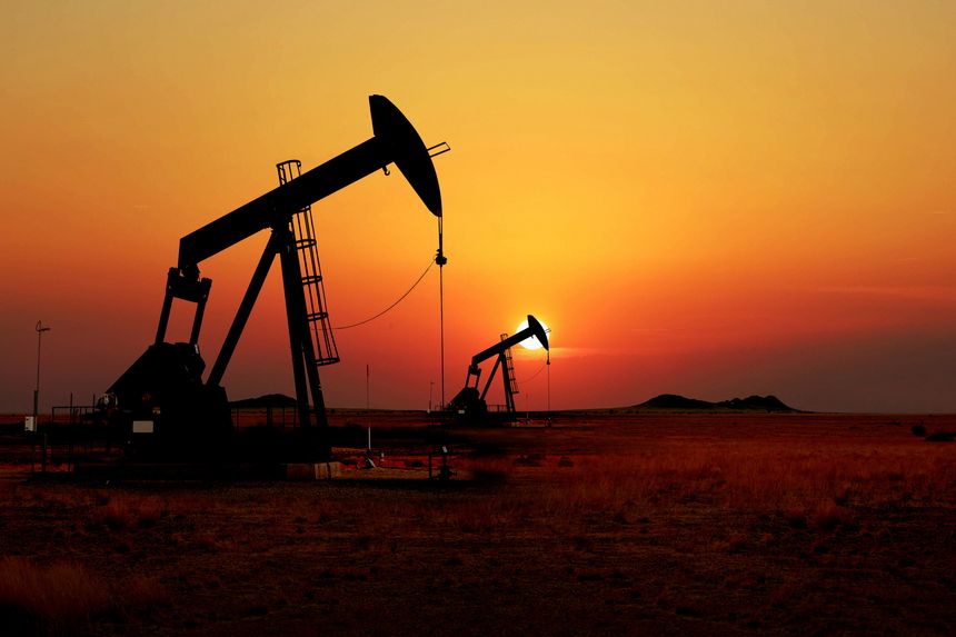 Silhouette of oil pump jacks at sunset in a desert field. Symbolizes Iranian oil production, energy crisis, and rising crude prices amidst escalating Middle East conflicts and Hormuz Strait tensions.