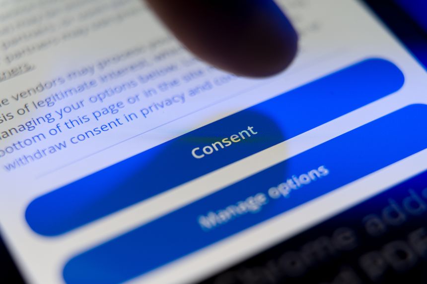 Close-up of a finger about to press a blue Consent button on a smartphone screen, concept for digital privacy, cookie policy, and user data agreement. High quality photo